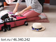 Young woman packing suitcase at home. Travel concept. Стоковое фото, фотограф Pixel_shot / Фотобанк Лори