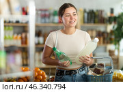 Girl hold packages bottles and choose consider soda water in store. Стоковое фото, фотограф Яков Филимонов / Фотобанк Лори