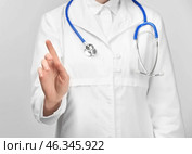 Female doctor showing something on white background. Стоковое фото, фотограф Pixel_shot / Фотобанк Лори