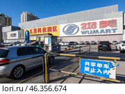 Автомобиль въезжает на парковку супермаркета Wumart, Пекин, Китай (2024 год). Редакционное фото, фотограф Кекяляйнен Андрей / Фотобанк Лори