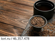 Bowl with dry hojicha green tea and cup of hot beverage on wooden background. Стоковое фото, фотограф Pixel_shot / Фотобанк Лори