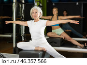 Gray-haired woman sitting on a Pilates platform. Стоковое фото, фотограф Яков Филимонов / Фотобанк Лори