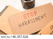 Cardboard with text STOP HARASSMENT on light background, closeup. Стоковое фото, фотограф Pixel_shot / Фотобанк Лори