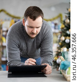 Male businessperson with tablet, plans to replenish restock stores inventory on Christmas Eve. Стоковое фото, фотограф Яков Филимонов / Фотобанк Лори