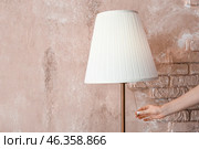 Woman turning on torchier near pink wall. Стоковое фото, фотограф Pixel_shot / Фотобанк Лори
