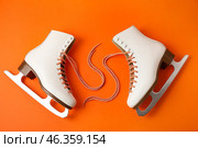 Pair of skates with untied laces on color background. Стоковое фото, фотограф Pixel_shot / Фотобанк Лори