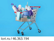 Shopping cart full of cleaning supplies and purple flowers on blue background. Стоковое фото, фотограф Pixel_shot / Фотобанк Лори