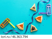 Hamantaschen cookies and rattles for Purim holiday on color background. Стоковое фото, фотограф Pixel_shot / Фотобанк Лори