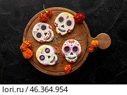 Board with cookies and marigold flowers on black background. El Dia de Muertos. Стоковое фото, фотограф Pixel_shot / Фотобанк Лори