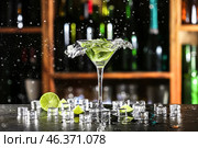 Glass of fresh mojito with splashes on table in bar. Стоковое фото, фотограф Pixel_shot / Фотобанк Лори