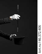 Male magician showing tricks on dark background. Стоковое фото, фотограф Pixel_shot / Фотобанк Лори