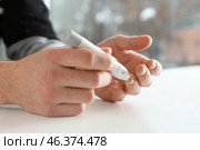 Man taking blood sample with lancet pen, closeup. Diabetes control. Стоковое фото, фотограф Pixel_shot / Фотобанк Лори