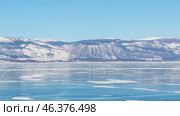 Video od winter Baikal Lake. Panoramic view of frozen Small Sea with beautiful blue clear ice surface and mountain range on sunny frosty February day. Natural background. Scenic landscape. Стоковое видео, видеограф Виктория Катьянова / Фотобанк Лори