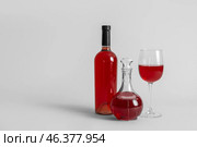 Decanter and bottle of wine with glass on grey background. Стоковое фото, фотограф Pixel_shot / Фотобанк Лори