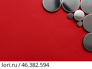 Metal lithium button cell batteries on red background, closeup. Стоковое фото, фотограф Pixel_shot / Фотобанк Лори