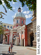 A mother and a girl on a scooter are standing near a church of the Holy Great Martyr and Healer Panteleimon (2022 год). Редакционное фото, фотограф Ирина Мойсеева / Фотобанк Лори