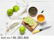 Composition with cup of tea, dried leaves and ripe bergamot fruits on light wooden background. Стоковое фото, фотограф Pixel_shot / Фотобанк Лори