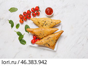 Plate with tasty Uzbek samsa and tomato sauce on white background. Стоковое фото, фотограф Pixel_shot / Фотобанк Лори