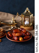 Plate with tasty dates and Arabic lamps on dark background. Стоковое фото, фотограф Pixel_shot / Фотобанк Лори