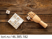 Game of Tic-Tac-Toe and decorative hand on wooden background. Стоковое фото, фотограф Pixel_shot / Фотобанк Лори