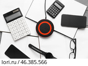 Wireless charger pad, gadgets and calculators on table. Стоковое фото, фотограф Pixel_shot / Фотобанк Лори