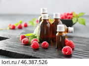 Bottles of raspberry essential oil on table. Стоковое фото, фотограф Pixel_shot / Фотобанк Лори
