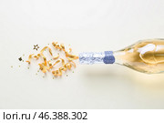 Bottle of champagne and glitters on white background. New year celebration. Стоковое фото, фотограф Pixel_shot / Фотобанк Лори