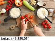 Woman cutting vegetables for rice casserole on table, top view. Стоковое фото, фотограф Pixel_shot / Фотобанк Лори