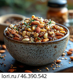 A bowl with a mix of nuts and seeds, including almonds, pumpkin and sunflower seeds, as well as other nuts and spices. They look fresh and delicious, with natural texturing that highlights their natural beauty. The bowl is made in a stylish ceramic design, which adds a cozy and natural feel. This image exudes an atmosphere of healthy eating and simplicity. Стоковое AI-изображение, AI-художник Анна Кривицкая / Фотобанк Лори