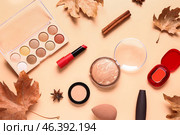 Composition with cosmetic products and autumn leaves on beige background. Стоковое фото, фотограф Pixel_shot / Фотобанк Лори