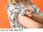 Woman with glucose sensor for measuring blood sugar level and applicator on orange background, closeup. Diabetes concept. Стоковое фото, фотограф Pixel_shot / Фотобанк Лори