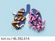 Paper lungs with flowers and cigarette butts on blue background, closeup. Stop smoking concept. Стоковое фото, фотограф Pixel_shot / Фотобанк Лори