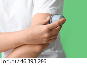 Woman with glucose sensor for measuring blood sugar level and applicator on green background, closeup. Diabetes concept. Стоковое фото, фотограф Pixel_shot / Фотобанк Лори