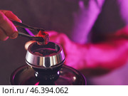 Man putting coal cubes on tobacco bowl, closeup. Стоковое фото, фотограф Pixel_shot / Фотобанк Лори
