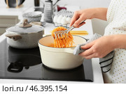 Woman cooking tasty pasta in kitchen. Стоковое фото, фотограф Pixel_shot / Фотобанк Лори