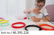Boy drawing with 3D pen at table. Стоковое видео, видеограф Igor Skripachev / Фотобанк Лори