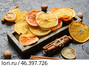 Dried citrus fruits, nutmegs and cinnamon on dark background. Стоковое фото, фотограф Pixel_shot / Фотобанк Лори