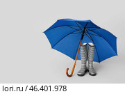Stylish umbrella with gumboots on light background. Стоковое фото, фотограф Pixel_shot / Фотобанк Лори