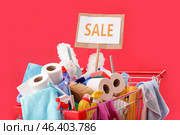 Shopping cart full of cleaning supplies and word SALE on red background. Стоковое фото, фотограф Pixel_shot / Фотобанк Лори