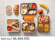 Many lunchboxes with different delicious food and bottle of juice on white tile background. Стоковое фото, фотограф Pixel_shot / Фотобанк Лори