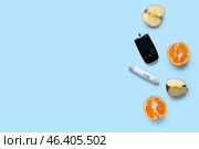 Digital glucometer, lancet and healthy fruits on blue background. Diabetes concept. Стоковое фото, фотограф Pixel_shot / Фотобанк Лори