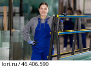 Girl glazer employee in blue overall works in glass processing shop. Стоковое фото, фотограф Яков Филимонов / Фотобанк Лори