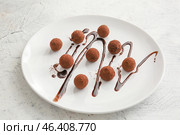 Tasty sweet truffles with chocolate sauce on plate. Стоковое фото, фотограф Pixel_shot / Фотобанк Лори