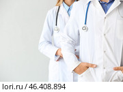 Male and female doctors on light background. Стоковое фото, фотограф Pixel_shot / Фотобанк Лори