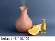 Aroma oil diffuser and citrus fruit on grey background. Стоковое фото, фотограф Pixel_shot / Фотобанк Лори