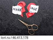 Broken heart, rings, scissors and torn paper with word MARRIAGE on dark background. Concept of divorce. Стоковое фото, фотограф Pixel_shot / Фотобанк Лори