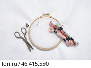 Wooden embroidery hoop with mouline threads, scissors and canvas as background. Стоковое фото, фотограф Pixel_shot / Фотобанк Лори