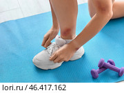 Young woman with bruises tying shoe laces in gym, closeup. Стоковое фото, фотограф Pixel_shot / Фотобанк Лори