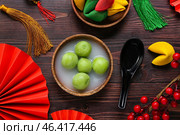 Bowl of tangyuan, fortune cookies and Chinese decor on dark wooden background. Dongzhi Festival. Стоковое фото, фотограф Pixel_shot / Фотобанк Лори