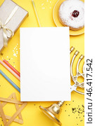 Blank card with menorah, doughnut, candles and gift for Hannukah celebration on yellow background. Стоковое фото, фотограф Pixel_shot / Фотобанк Лори